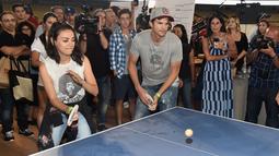 Pasangan selebriti, Mila Kunis (kiri) dan Ashton Kutcher (kanan) saat bermain pingpong di acara tahunan ke-6 dari Clayton Kershaw, Ping Pong 4 Purpose, Los Angeles, Amerika Serikat, Kamis (23/8). (CHRISTOPHER POLK/GETTY IMAGES NORTH AMERICA/AFP)