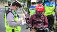 Polisi Lalu lintas menilang pengendara sepeda motor saat Operasi Patuh Jaya 2020 di Jalan Letjen Suprapto, Jakarta Pusat, Kamis (23/7/2020). Ditlantas Polda Metro Jaya menggelar Operasi Patuh Jaya 2020 hingga 5 Agustus untuk menertibkan masyarakat dalam berlalu lintas. (Liputan6.com/Faizal Fanani)