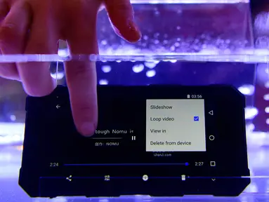 Pengunjung menguji smartphone tahan air Nomu S50 Pro dalam gelaran Mobile World Congress (MWC) 2019 di Barcelona, Spanyol, Senin (25/2). Perusahaan fokus pada layar yang dapat dilipat dan pengenalan jaringan nirkabel 5G. (GABRIEL BOUYS/AFP)