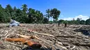 Pemerintah Provinsi Aceh menyebutkan, bencana kali ini menjadi yang terparah setelah gempa dan tsunami 2004. Tampak dalam foto, orang-orang berjalan melintasi lumpur dan puing-puing di daerah terdampak banjir di Meureudu, Kabupaten Pidie Jaya, Provinsi Aceh, pada 30 November 2025. (CHAIDEER MAHYUDDIN/AFP)