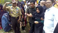 Ibunda Sertu Anumerta Dita Ilham (dua dari kanan) dipapah keluar dari pemakaman. (Foto: Liputan6.com/Rudal Afgani Dirgantara)