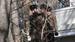 Tiga tentara Korea Utara mengawasi kunjungan Menhan Korsel, Song Young-moo di zona Demiliterisasi Panmunjom, (27/11). Tentara Korut terus mengawasi kunjungan Song Young-moo dan mendengarkan pembicaraan dengan jarak hanya 10 meter. (AP Photo/Lee Jin-man)