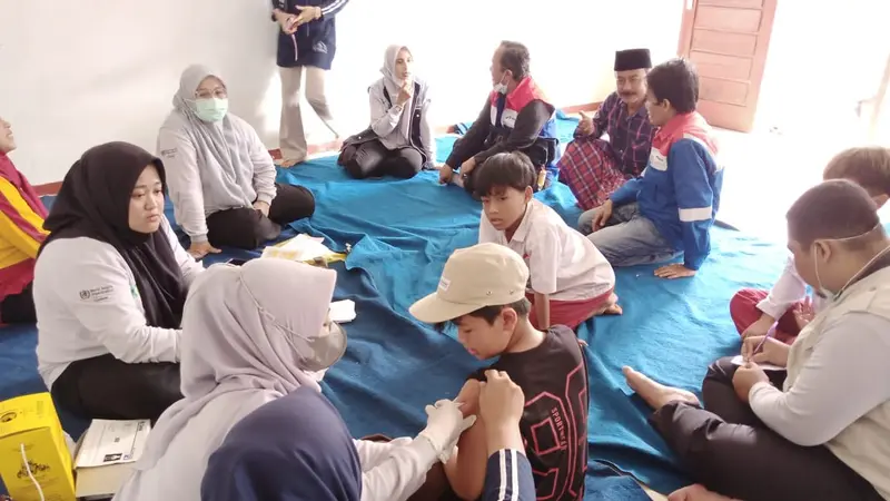 Tim Dokter dan Governance Public Relation PGE Area Karaha tengah melakukan vaksinasi imunisasi difteri warga Desa Sukahurip, Garut, Jawa Barat. (Liputan6.com/Jayadi Supriadin)
