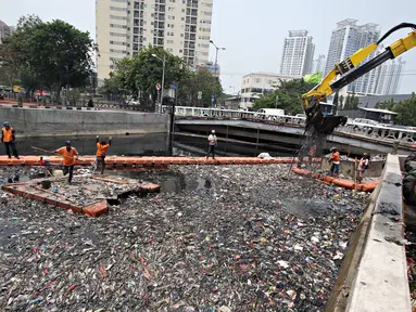 Pekerja tengah mengangkut sampah yang memenuhi Kali Sentiong, Sunter, Jakarta, Kamis (12/11). Sistem pengelolaan sampah yang buruk di Ibukota menjadi salah satu penyebab Kali Sentiong kerap dipenuhi sampah. (Liputan6.com/Immanuel Antonius)