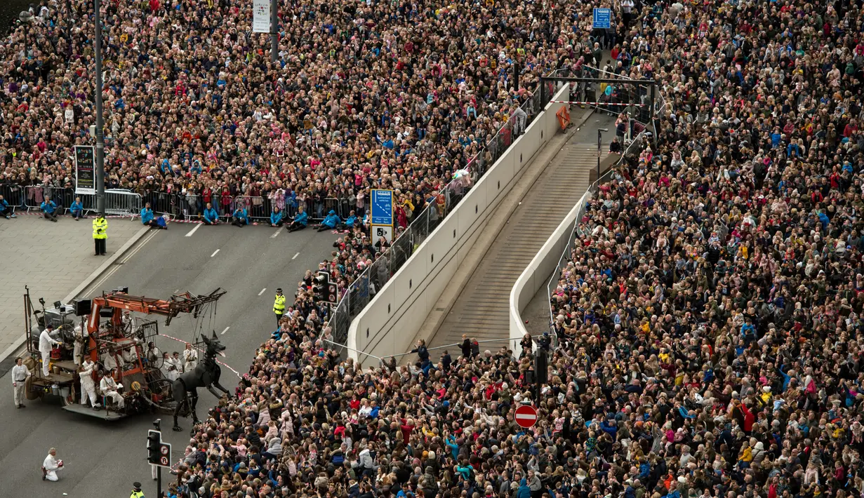 Kerumuman warga melihat boneka anjing raksasa bernama Xolo melewati dermaga di Liverpool, Inggris, Minggu (7/10). Boneka itu karya dari kelompok teater jalanan Prancis, Royal de Luxe dengan ciri khas aktor berupa Boneka Super Besar. (OLI SCARFF/AFP)