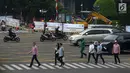 Warga menyeberang jalan dekat proyek pelebaran jalur khusus pejalan kaki atau pedestrian di kawasan Sarinah, Jakarta, Rabu (4/7). Pelebaran ini dilakukan untuk menyambut Asian Games 2018. (Merdeka.com/Imam Buhori)