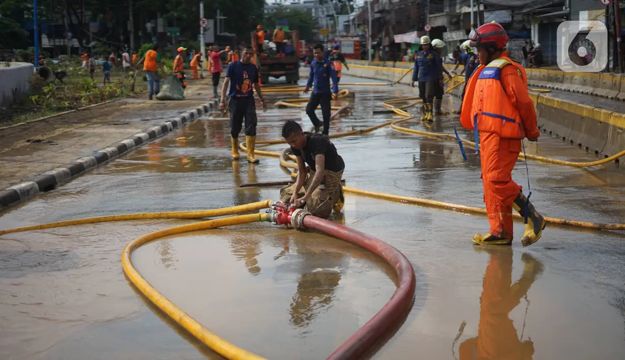Suasana saat petugas Penanganan Prasaran dan Sarana Umum (PPSU) membersihkan lumpur yang mengendap di sepanjang Jalan Jatinegara Barat, Kampung Melayu, Jakarta Timur, Kamis (2/1/2020). Petugas melakukan bersih-bersih menyusul mulai surutnya banjir di kawasan itu.(Liputan6.com/Immanuel Antonius)