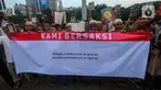 Massa dari Jamaah Muslimlin (Hizbulloh) melakukan aksi simpatik mengutuk pembakaran  Alquran di luar masjid utama Stockholm pada 28 Juni 2023 di kawasan Patung Kuda, Jakarta, Minggu (2/7/2023). Aksi dilakukan dengan menandatangani dukungan dan pembacaan kitab suci Alquran. (merdeka.com/Arie Basuki)