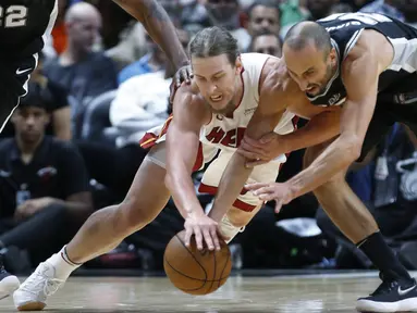 Pemain Miami Heat, Kelly Olynyk (tengah) berebut bola dengan pemain San Antonio Spurs, Manu Ginobili (kanan) pada laga NBA basketball game di Miami, (25/10/2017). Spurs kalahkan Heat 117-100. (AP/Wilfredo Lee)