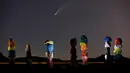 Komet Neowise, atau C / 2020 F3, terlihat di langit malam di atas karya seni berjudul: "Tujuh Magic Mountains" oleh seniman Ugo Rondinone di dekat Jean, Nev., Sebelah selatan Las Vegas, Kamis (16/7/2020). (AP Photo/John Locher)