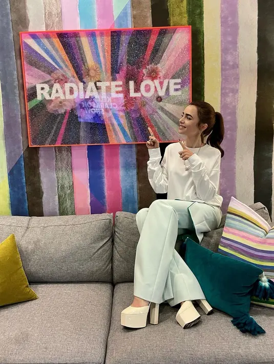 Tampil kasual dengan sweater putih dan flare pants baby blue dengan sepatu platform yang menjadi pernyataan gaya (Foto: Instagram @lilyjcollins)