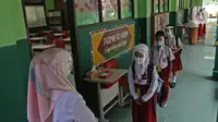 Sejumlah murid menerapkan jaga jarak sebelum masuk ke sekolah di SD Negeri 6, Bekasi, Jawa Barat, Selasa (4/8/2020). Pemerintah setempat memberikan izin kepada enam sekolah untuk melakukan uji coba pembelajaran tatap muka selama satu bulan. (Liputan6.com/Herman Zakharia)