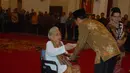 Likas Boru Tarigan menerima penghargaan sebagai ahli waris untuk Letjen Djamin Gintingdi Istana Negara, Jakarta, Jumat (7/11/2014). (Liputan6.com/Herman Zakharia)
