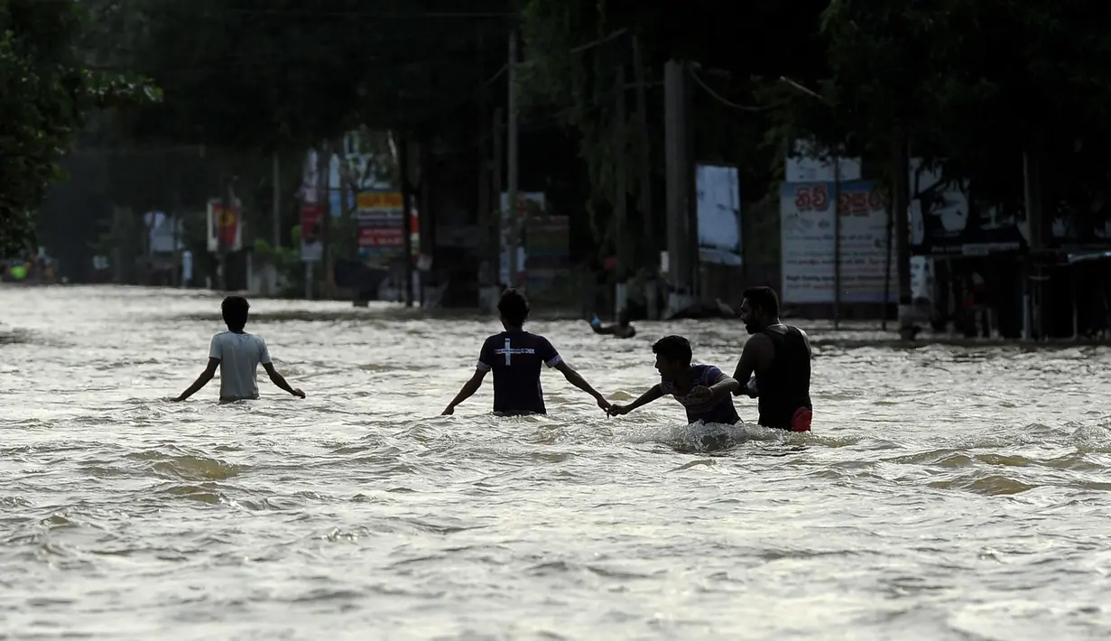 Warga Sri Lanka melewati banjir yang menerjang kawasan mereka di Kaduwela, Kolombo, Sabtu (21/5/2016). Dikabarkan sekitar 80 orang tewas akibat hujan dan tanah longsor yang melanda Sri Lanka. (AFP Photo/Ishara S Kodikara)