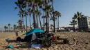 Seorang pria tunawisma bermain drum pada pagi hari di Venesia, California, Amerika Serikat, 12 Agustus 2021. (Apu GOMES/AFP)
