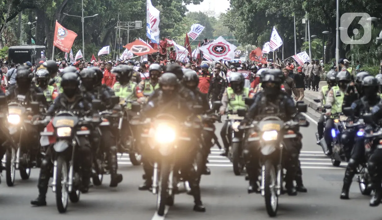 Aparat kepolisian mengawal aksi konvoi massa dari Konfederasi Serikat Buruh Seluruh Indonesia (KSBSI) di Jalan Medan Merdeka Barat, Jakarta, Senin (12/10/2020). Mereka hendak berunjuk rasa menolak pengesahan omnibus law Undang-Undang Cipta Kerja di Istana Negara. (merdeka.com/Iqbal S Nugroho)