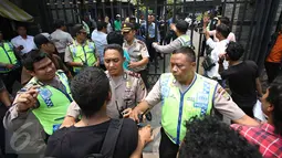 Polisi mencoba menahan massa dari Massa dari Solidaritas Pergerakan Mahasiswa Indonesia yang memaksa melakukan demo di depan Kantor DPP Partai NasDem, Jakarta, Senin (18/1). Kejadian tersebut juga diwarnai aksi lempar batu.(Liputan6.com/Immanuel Antonius)