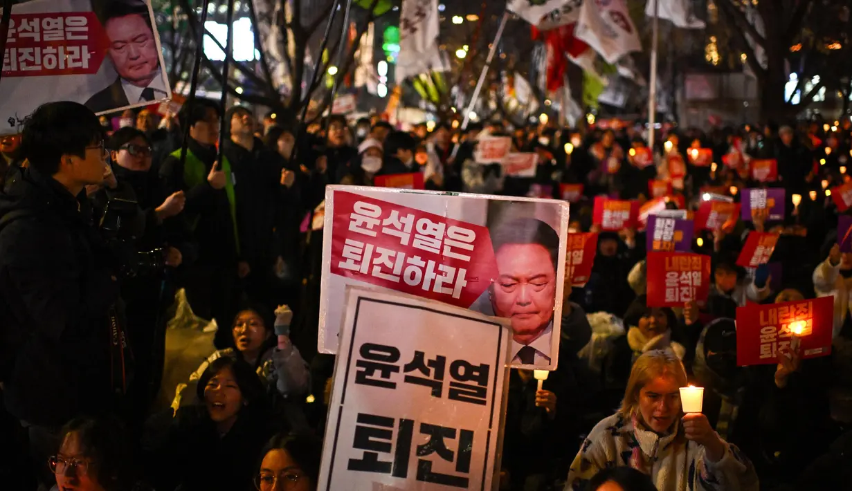 Keputusan Presiden Korea Selatan Yoon Suk Yeol terkait pemberlakuan darurat militer sontak mendorong ribuan orang untuk berkumpul di depan parlemen untuk melakukan protes. (Philip FONG/AFP)