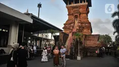 Peziarah berfoto dengan latar Menara Kudus, Kauman, Kabupaten Kudus, Jawa Tengah, Rabu (30/3/2022). Menara berusia 473 tahun yang dahulu berfungsi sebagai tempat mengumandangkan azan menjadi lokasi favorit pengunjung untuk bersantai usai berziarah di Makam Sunan Kudus. (merdeka.com/Iqbal S. Nugroho)