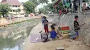 Suasana di bantaran anak Sungai Ciliwung, Jakarta, Rabu (6/6). Meskipun tidak layak sebagai tempat bermain, namun lokasi itu menjadi tempat bagi anak-anak di kawasan tersebut untuk menunggu waktu berbuka. (Liputan6.com/Immanuel Antonius)