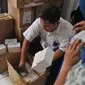 Petugas memeriksa kemasan kardus telepon seluler ilegal di gudang distributor, di ruko kawasan Cempaka Mas, Jakarta, Senin(15/6/2015). Penggeledahan tersebut terkait beberapa laporan dari masyarakat. (Liputan6.com/Herman Zakharia)