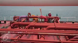 Pekerja melakukan pengecekan kapal M.T Jhon Caine yang digunakan untuk menyuplai BBM di Terminal BBM Panjang, Bandar Lampung, Selasa (6/10/2015). Terminal BBM Panjang akan menjadi Integrated End to End Pertama di Indonesia. (Liputan6.com/Angga Yuniar)