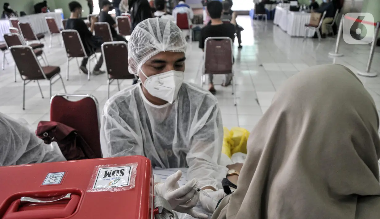 Tenaga kesehatan melakukan tes kesehatan warga sebelum disuntik vaksin dosis ketiga (Booster) di Pasar Induk Kramat Jati, Jakarta Timur, Kamis (10/3/2022). Kepala Dinas Kesehatan DKI Jakarta Widyastuti mengakui, capaian vaksinasi booster COVID-19 masih sangat rendah. (merdeka.com/Iqbal S. Nugroho)