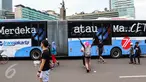 Sebuah bus TransJakarta koridor 1 dengan stiker bertuliskan Merdeka atau Macet melintas ketika masyarakat Jakarta tengah berolahraga saat Car Free Day (CFD) di kawasan Bundaran HI, Jakarta, (14/08). (Liputan6.com/Fery Pradolo).