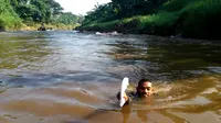 Seorang pria berenang di Ciliwung untuk Temui Ahok (Delvira Chaerani Hutabarat/Liputan6.com)