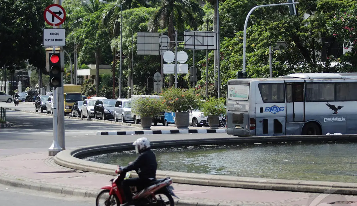 Pengendara di dekat papan petunjuk larangan motor melintasi jalur menuju Jalan MH Thamrin, Jakarta. Foto diambil pada Senin (15/12/2014). (Liputan6.com/Faizal Fanani)