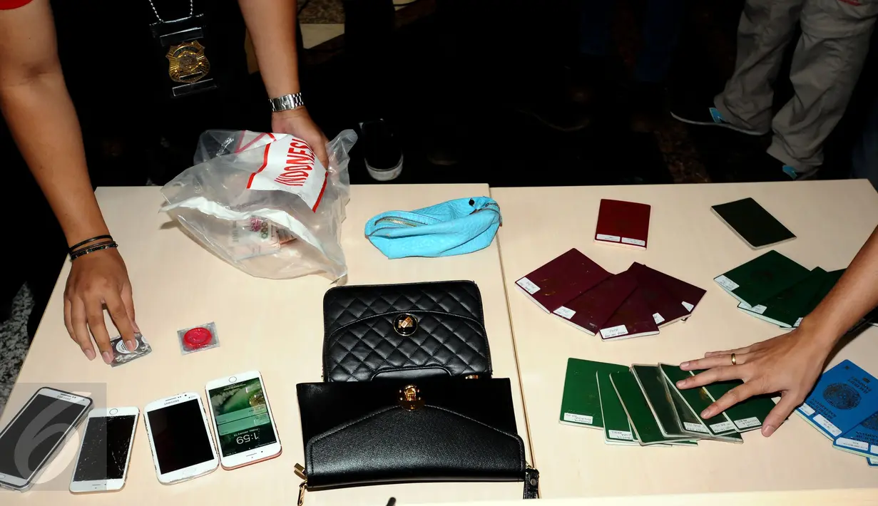 Petugas menunjukkan barang bukti hasil pengamanan 32 WNA illegal dalam operasi pengawasan orang asing saat rilis di Ditjen Imigrasi, Jakarta, Jumat (13/1). Diduga, para WNA tersebut bekerja sebagai PSK. (Liputan6.com/Helmi Fithriansyah)
