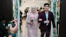 Inilah momen perayaan ulang tahun pernikahan ke-1 Ria Ricis dan Teuku Ryan. Keduanya masuk ke mimbar berlangsungnya pesta dengan penuh senyum semringah. Kebahagiaan sangat terlihat di raut wajah mereka. Semua tamu yang hadir pun siap menyambut kedatangan raja dan ratu dalam acara tersebut. (Liputan6.com/IG/@serunniwedding)