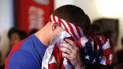 Salah satu pendukung Timnas Amerika Serikat menutupi wajahnya saat menyaksikan gol kedua Portugal yang dicetak Silvestre Varela di Los Angeles, Kalifornia, (22/6/2014). (REUTERS/Lucy Nicholson) 