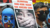 Poster-poster tuntutan dibentangkan saat massa yang tergabung dalam Aliansi Mahasiswa Islam (AMI) melakukan aksi unjuk rasa di depan Kedutaan Besar (kedubes) China, Kuningan, Jakarta Selatan, Jumat (3/2/2023). Selain berorasi, mereka juga menggelar aksi teatrikal dan membawa spanduk tuntutan dalam aksi tersebut. (merdeka.com/Imam Buhori)