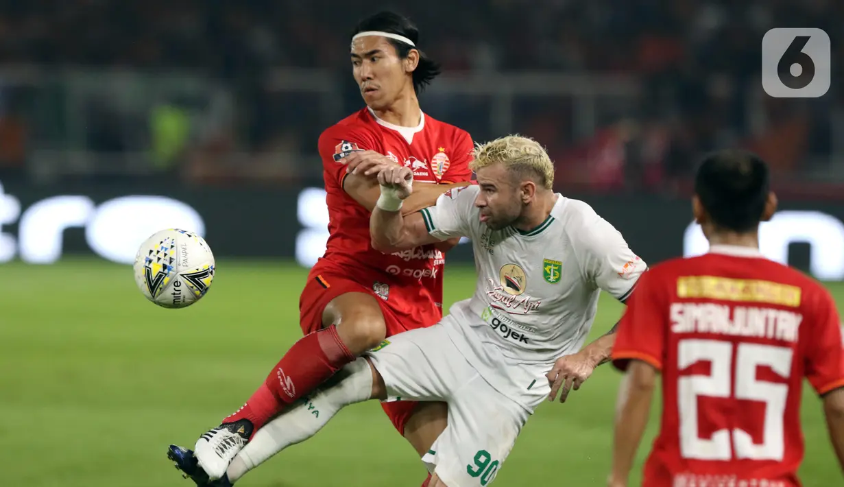 Bek Persija, Ryuji Utomo (kiri) berebut bola dengan pemain tengah Persebaya, Diogo Campos Gomes pada lanjutan Shopee Liga 1 Indonesia di Stadion Utama Gelora Bung Karno Jakarta, Selasa (17/12/2019). Persija kalah 1-2 dari Persebaya. (Liputan6.com/Helmi Fithriansyah)