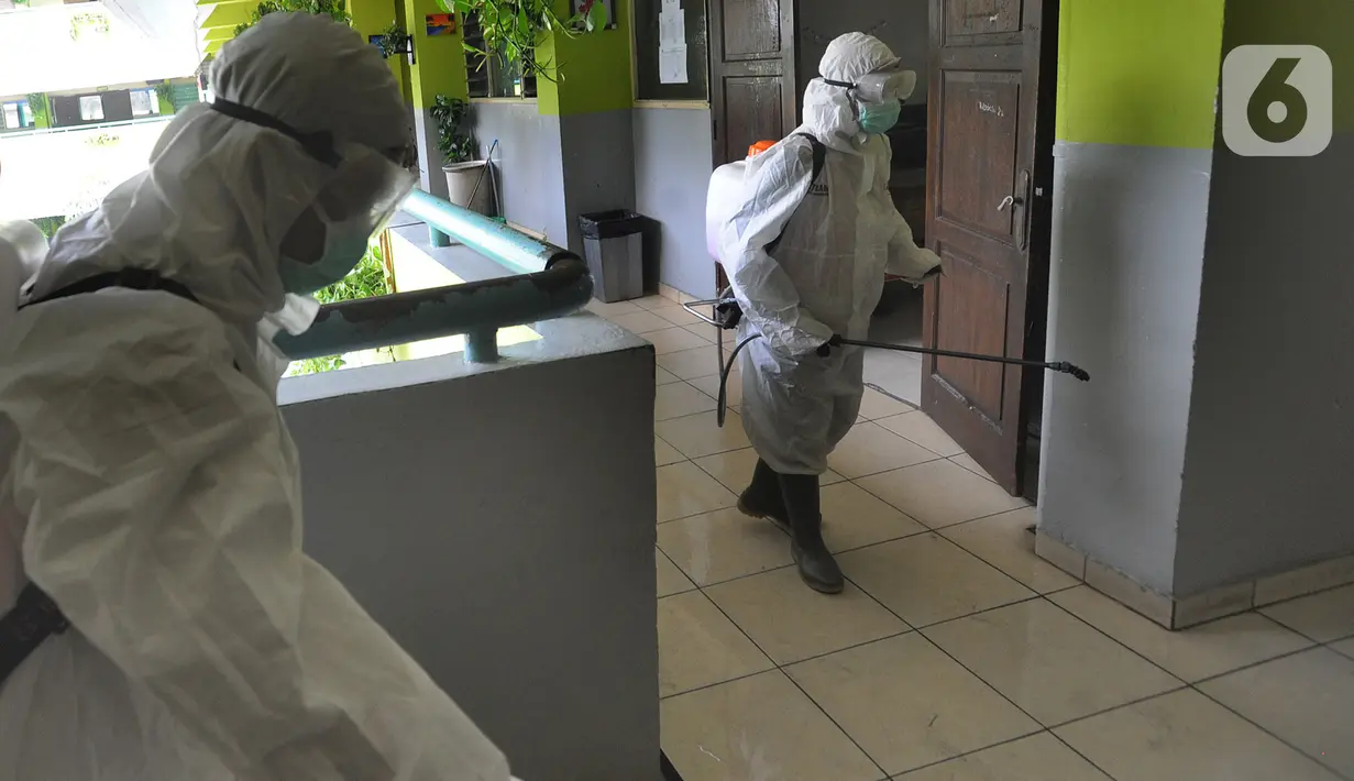 Petugas Palang Merah Indonesia (PMI) melakukan penyemprotan disinfektan di SMPN 216 Jakarta, Senin (16/3/2020). Mulai hari ini, aktivitas sekolah di sejumlah wilayah Indonesia diliburkan untuk mengantisipasi penyebaran virus corona COVID-19. (merdeka.com/Arie Basuki)