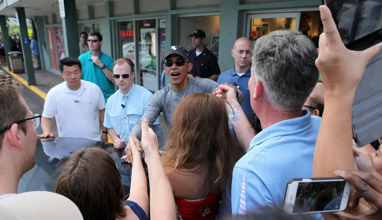 Presiden AS Barack Obama berjabat tangan dengan warga usai membeli es disebuah toko minuman dengan keluarga dan teman-teman selama liburan Natal di Kailua, Hawaii, (27/12/2015). (REUTERS/Hugh Gentry)