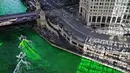 Wisatawan berkumpul mengamati sungai Chicago di Illinois, AS yang berubah warna menjadi hijau, 11 Maret 2017. Hijaunya warna sungai itu sebenarnya berasal dari cairan pewarna khusus untuk perayaan St. Patrick's Day. (John J. Kim/Chicago Tribune via AP)