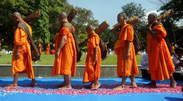 Calon biksu Buddha yang disebut samanera berjalan tanpa alas kaki sekitar empat kilometer dari Candi Mendut ke Candi Borobudur dalam ritual tahunan Pabbaja Samanera, pelatihan moral dan spiritual selama 12 hari bagi calon biksu, di Magelang, Jawa Tengah, 27 Desember 2023. (DEVI RAHMAN/AFP)