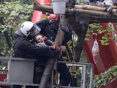 Polisi menyeret aktivis lingkungan dari sebuah rumah pohon di hutan Hambacher Forst di Kerpen, Jerman Barat (13/9). Aktivis yang tinggal di rumah pohon tersebut menghadapi penggusuran paksa oleh polisi. (Henning Kaiser/dpa/AFP)