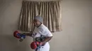 Seorang nenek usai berlatih tinju pada Boxing Gogos di Cosmo City, Johannesburg, Selasa (19/9/2017). Berkat latihan rutin yang dipimpin Claude Maphosa ini para lansia berhasil sembuh dari penyakit dan hidup lebih sehat. (AFP/Gulshan Khan) 