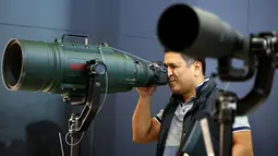 Pengunjung mencoba mengoperasikan lensa supertele Sigma pada stand Kamera Sigma saat berlangsungnya Pameran Photokina di Cologne, Jerman, (20/9). Pameran Photokina pertama diadakan di Cologne, Jerman, pada tahun 1950. (REUTERS/Fabrizio Bensch)