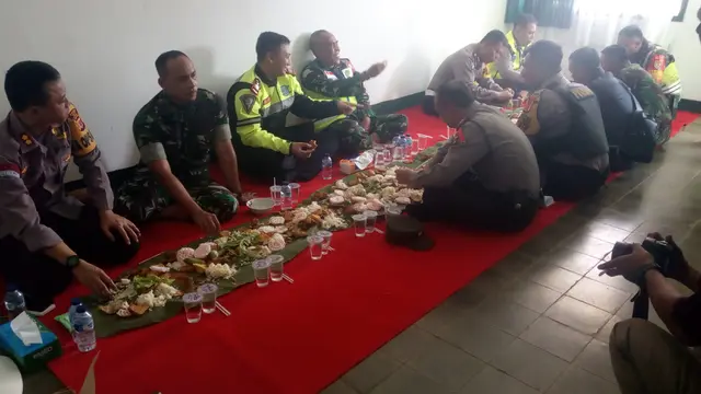 Beralaskan daun pisang, anggota TNI-Polri Garut nampak akrab menyantap makanan nasi liwet yang disediakan koramil Sukawening