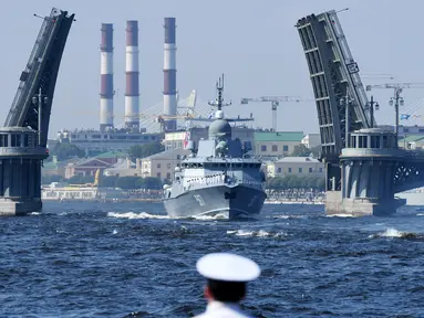 Seorang pelaut menyaksikan kapal perang Rusia berlayar selama parade Hari Angkatan Laut di Sungai Neva, Saint Petersburg, Rusia, Minggu (29/7). (Kirill Kudryavtsev/AFP)