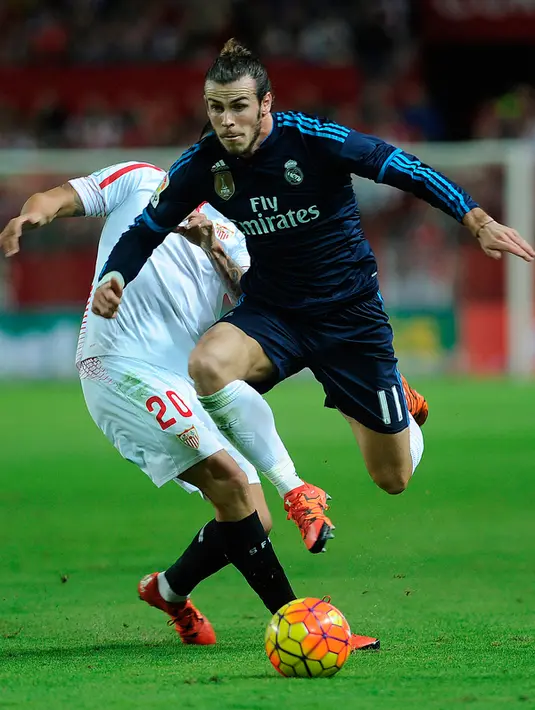 Gelandang Real Madrid, Gareth Bale (kanan) berusaha melewati pemain Sevilla pada lanjutan La Liga di Estadio Ramon Sanchez Pizjuan, Spanyol (9/11/2015). Sevilla menang atas Real Madrid dengan skor 3-2. (AFP PHOTO/CRISTINA QUICLER)