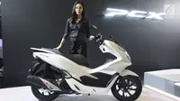 Seorang berpose dengan skutik all new Honda PCX saat peluncurannya di Jakarta, Rabu (7/2). President Director PT AHM Toshiyuki Inuma berharap all new PCX dapat memenuhi keseluruhan ekspektasi konsumen atas teknologi. (Liputan6.com/Angga Yuniar)