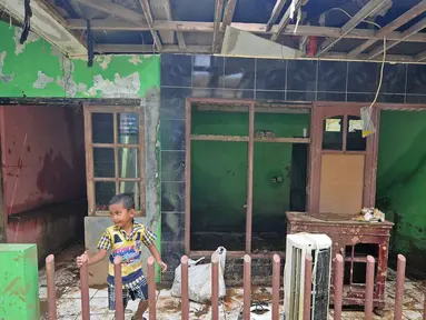 Seorang anak bermain di rumah yang rusak akibat terjangan banjir di kawasan  Balekambang, Kramatjati, Jakarta Timur, Selasa (30/4/2019). Sejumlah rumah warga di RT 005/RW 005 Balekambang rusak diterjang banjir yang terjadi pada 27 April 2019 lalu. (Liputan6.com/Herman Zakharia)