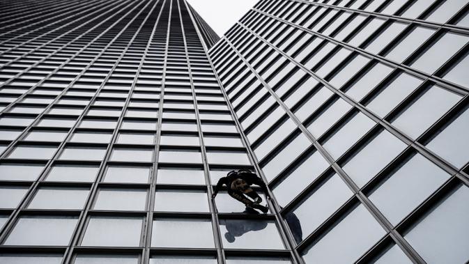 Pendaki Alain Robert atau French Spiderman memanjat Menara Total di kawasan bisnis La Defense, Paris, Prancis, Senin (13/1/2020). Hingga saat ini, pria berusia 57 tahun tersebut sudah memanjat lebih dari 100 bangunan di dunia. (Thomas SAMSON/AFP)