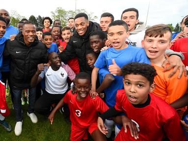 Pemain Timnas Prancis, Anthony Martial dan Patrice Evra, berfoto bersama pemain muda Les Ulis, (23/5/2016). Les Ulis adalah klub masa kecil keduanya. (AFP/Franck Fife) 