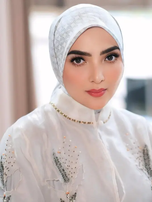 Ashanty tampil memukau dalam balutan tunik dan hijab yang elegan, dilengkapi dengan sentuhan aksesori mewah. [@ashanty_ash].